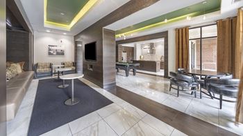 A rendering of a lobby with tables and chairs and a television
